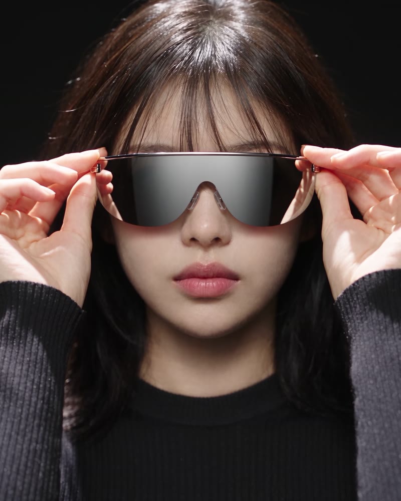 Mikaela putting on silver shield sunglasses